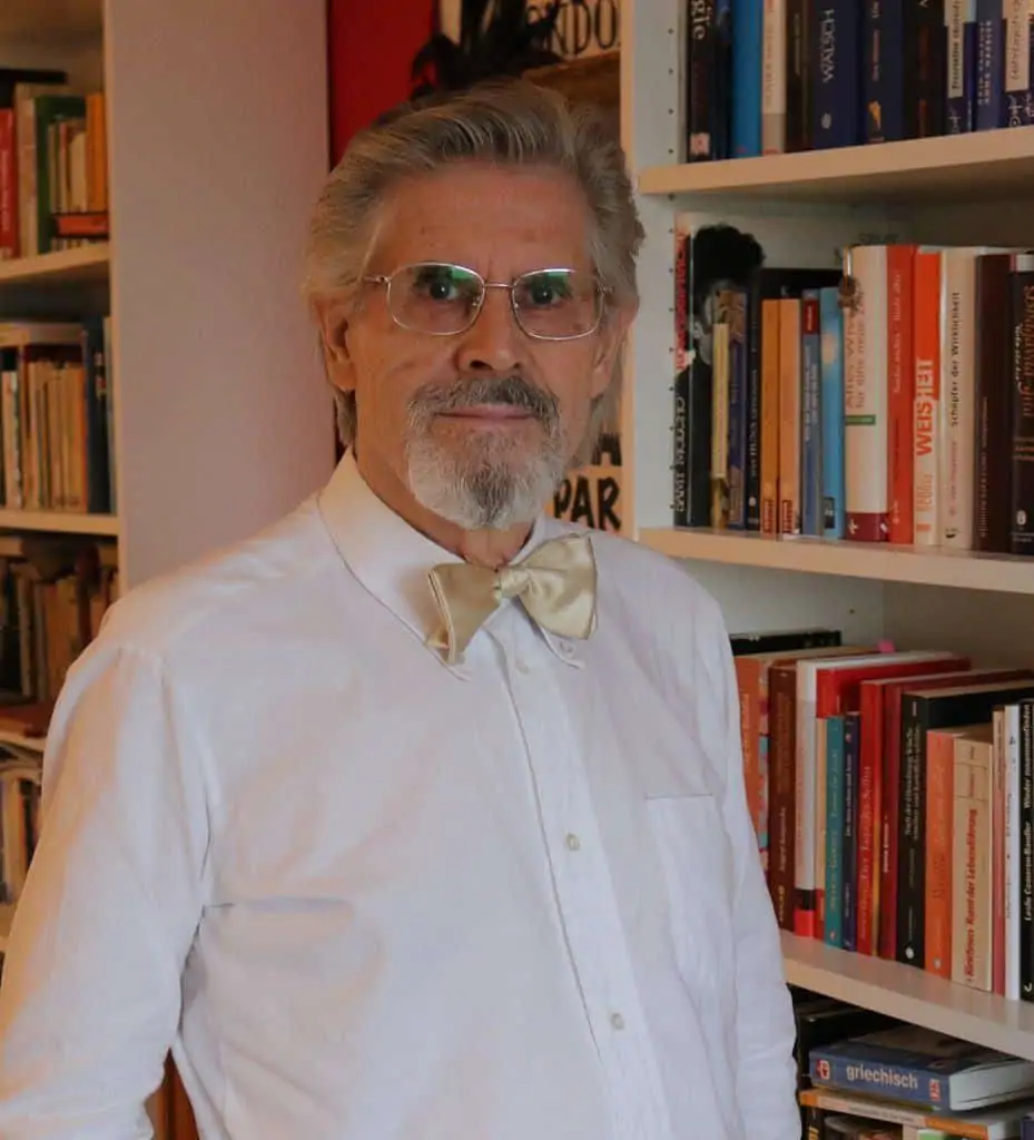 Mentaltrainer und Astrologe Manfred Peter Lederer vor einem Bücherregal